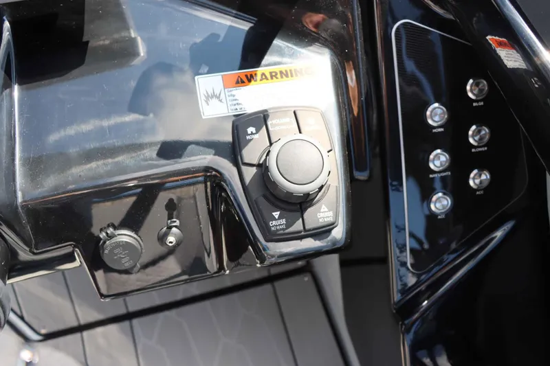 Slide: The Image of 2024 Yamaha Boats 255XE dashboard controls with warning label and buttons. - 32