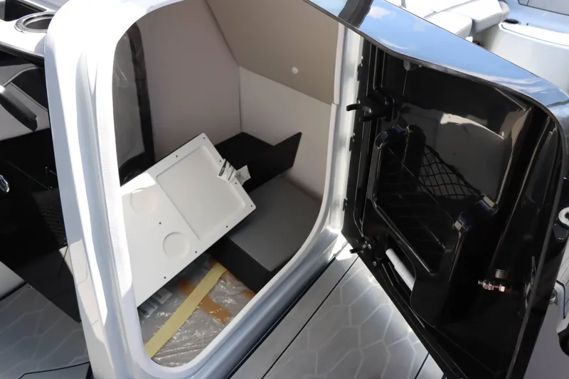 Slide: The Image of 2024 Yamaha Boats 255XE interior storage compartment with open door. - 33