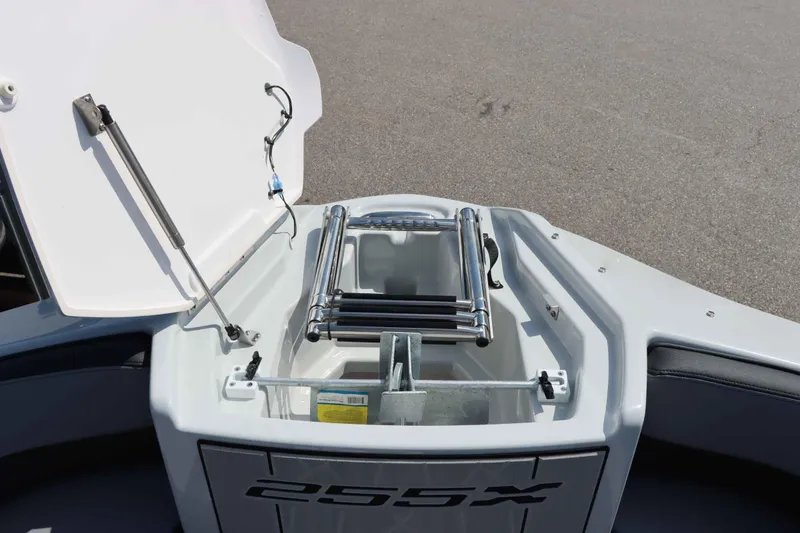 Slide: The Image of 2024 Yamaha Boats 255XE bow storage compartment with ladder and hatch open. - 37