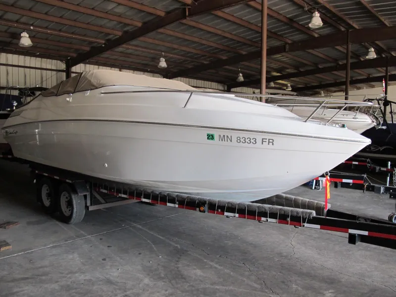 The Image of 1992 Chris-Craft 228 Concept Cuddy boat on trailer in storage facility. - 1