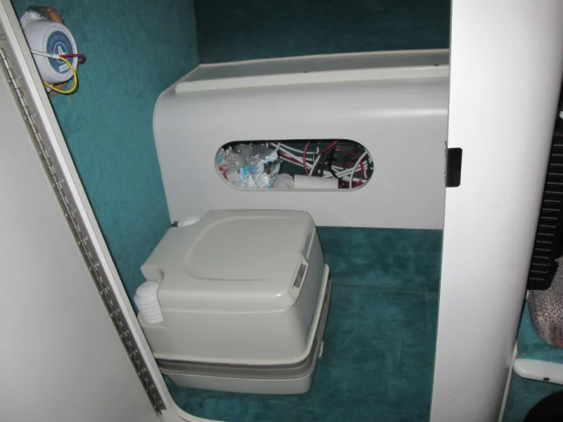 Slide: The Image of 1992 Chris-Craft 228 Concept Cuddy cabin interior with portable toilet and storage compartment. - 10