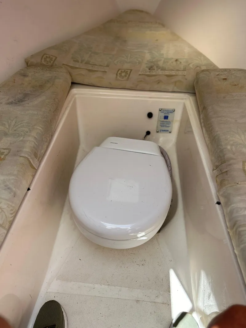 Slide: The Image of 2003 Salt Shaker Custom Edition 30 boat interior with toilet and cushioned seating. - 12