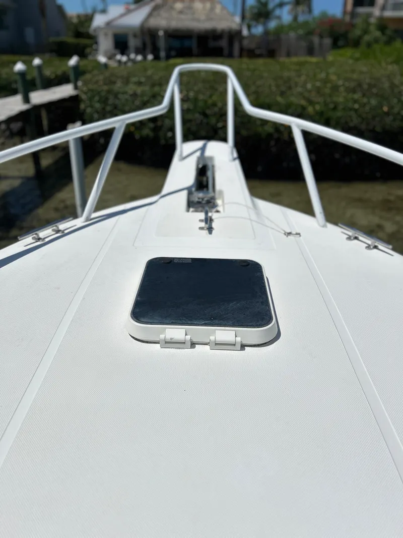 Slide: The Image of Bow of 2003 Salt Shaker Custom Edition 30 boat docked near lush greenery. - 14