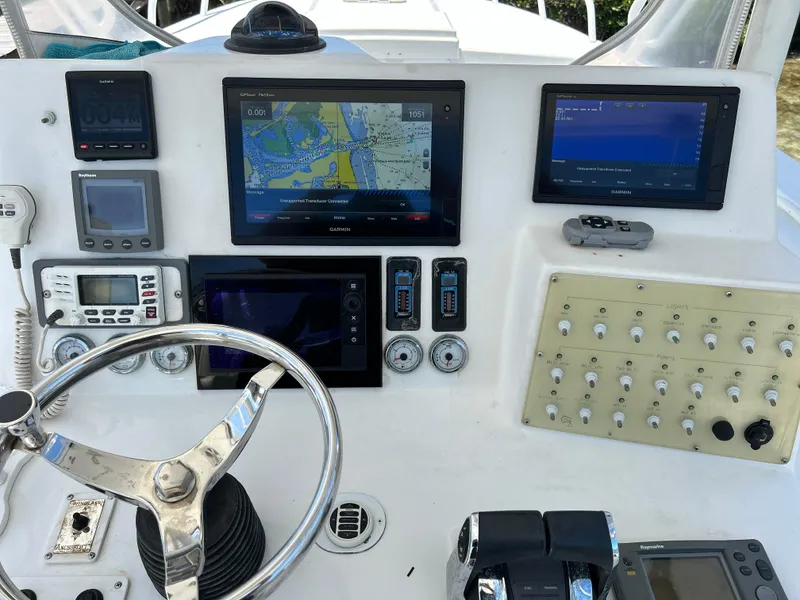 Slide: The Image of Control panel of a 2003 Salt Shaker Custom Edition 30 boat with navigation screens and steering wheel. - 8