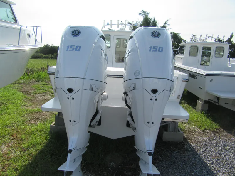 Slide: The Image of 2025 Parker 2420 Sport Cabin with twin 150 horsepower outboard engines, docked outdoors. - 4
