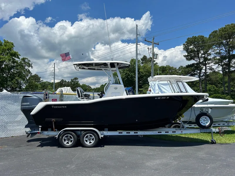 The Image of 2019 Tidewater 232 CC Adventure boat on a trailer with an American flag in the background. - 0