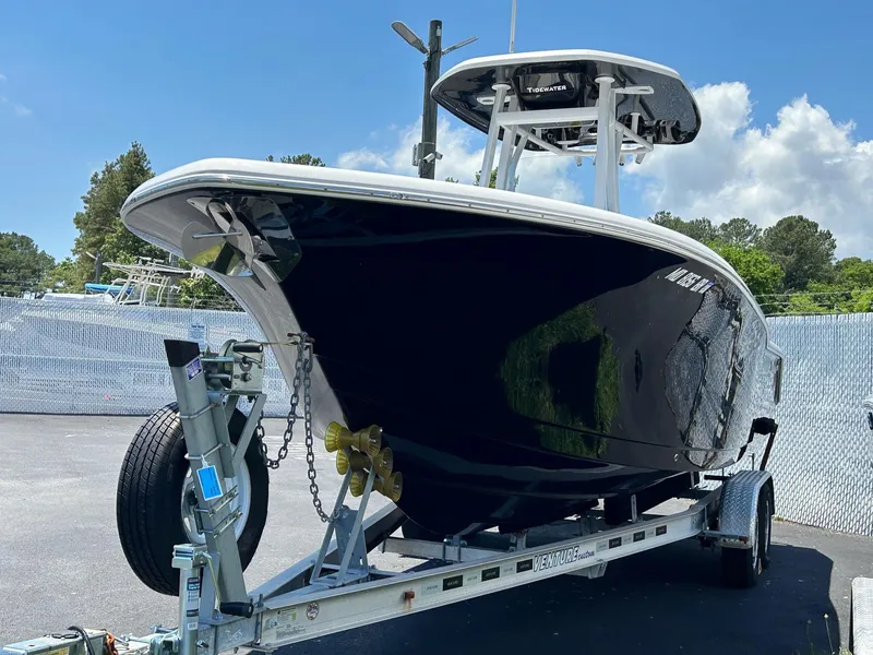 Slide: The Image of 2019 Tidewater 232 CC Adventure boat on a trailer, black hull, outdoor setting. - 10