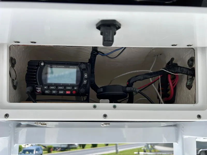 Slide: The Image of 2019 Tidewater 232 CC Adventure boat electronics compartment with radio and wiring. - 25