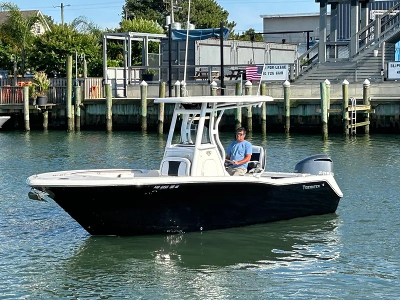 Slide: The Image of 2019 Tidewater 232 CC Adventure boat on water near dock. - 5