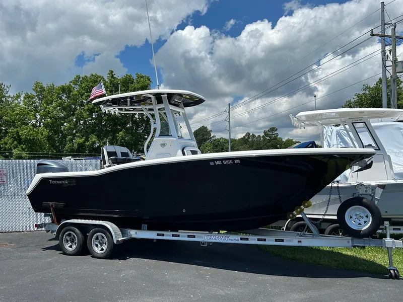 Slide: The Image of 2019 Tidewater 232 CC Adventure boat on a trailer under a partly cloudy sky. - 7