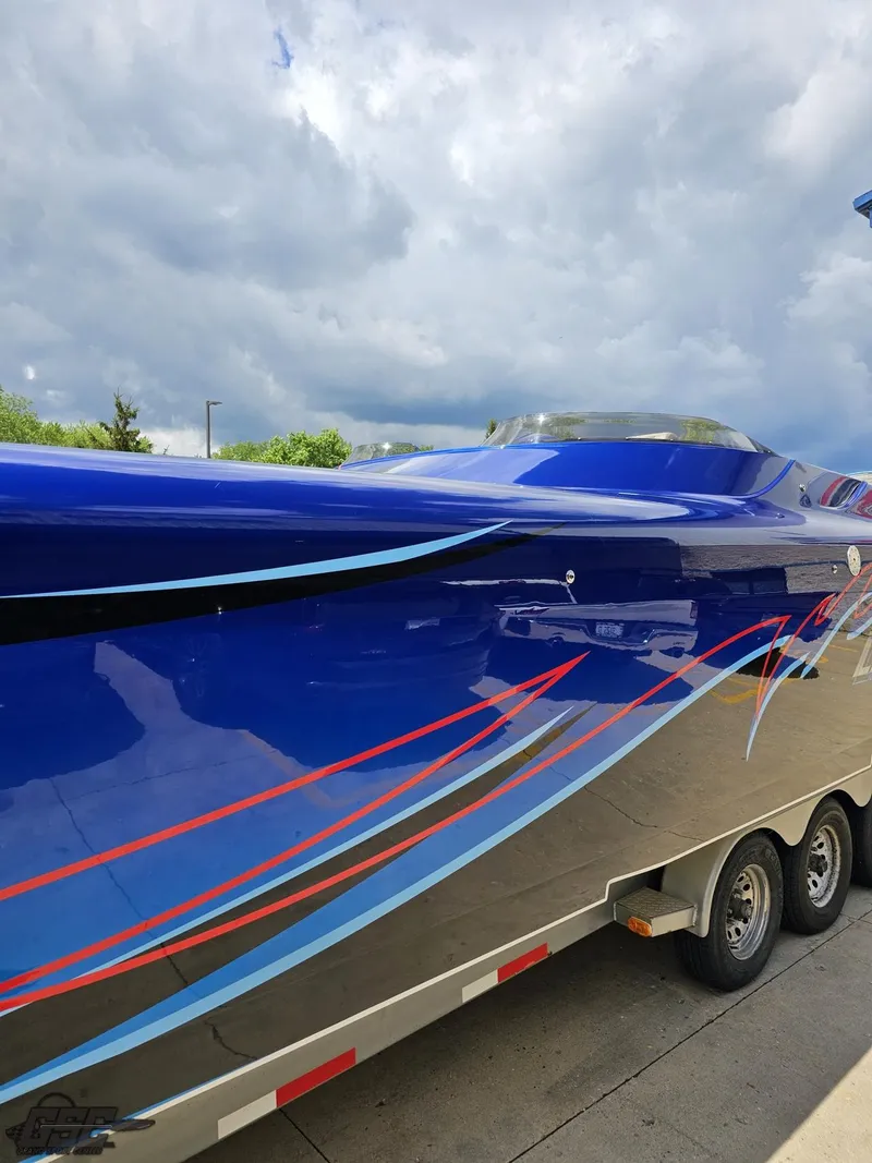 Slide: The Image of 2011 Catamaran Liquid Glass 41 boat with vibrant blue and red design on trailer. - 30