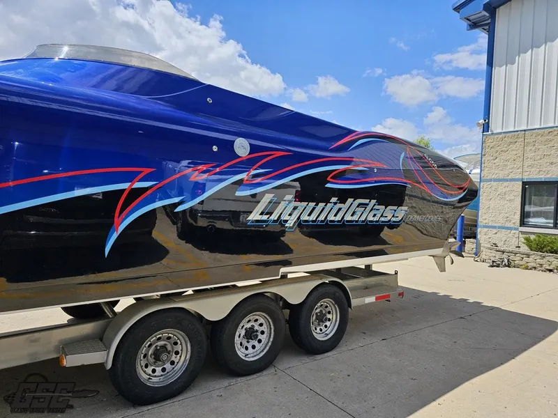 Slide: The Image of 2011 Catamaran Liquid Glass 41 boat on a trailer, blue with red and white accents. - 31