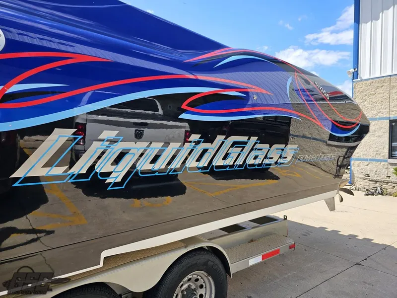 Slide: The Image of 2011 Catamaran Liquid Glass 41 boat on trailer with vibrant graphics. - 32