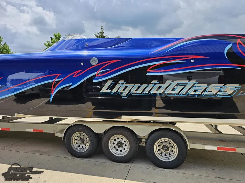 Slide: The Image of 2011 Catamaran Liquid Glass 41 on a trailer, side view with vibrant graphics. - 34
