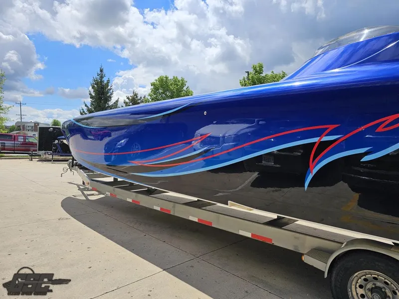 Slide: The Image of 2011 Catamaran Liquid Glass 41 on trailer, blue with red and blue graphics. - 35