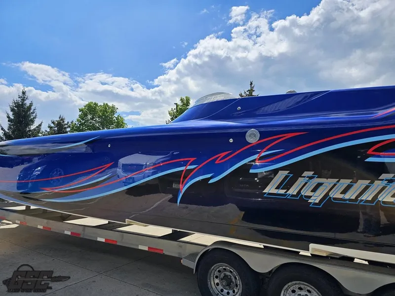 Slide: The Image of 2011 Catamaran Liquid Glass 41 boat on trailer with vibrant blue and red graphics. - 38