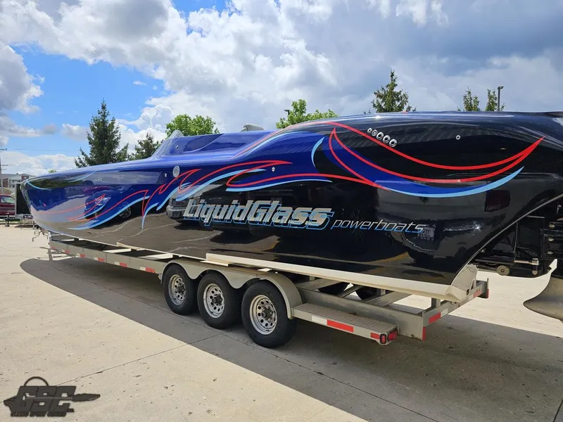 Slide: The Image of 2011 Catamaran Liquid Glass 41 powerboat on a trailer under a partly cloudy sky. - 41