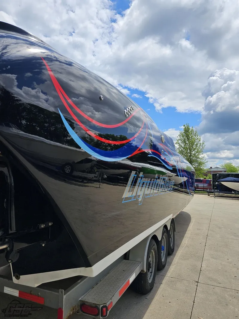 Slide: The Image of 2011 Catamaran Liquid Glass 41 boat on a trailer under a partly cloudy sky. - 49
