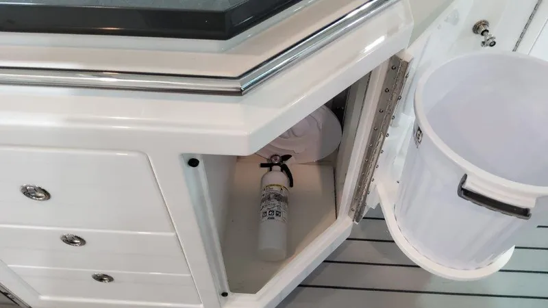 Slide: The Image of 2023 Formula 380 Super Sport Crossover OB interior storage with fire extinguisher and trash bin. - 25