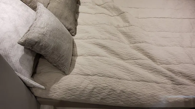 Slide: The Image of 2023 Formula 380 Super Sport Crossover OB cabin bed with beige quilt and pillows. - 37