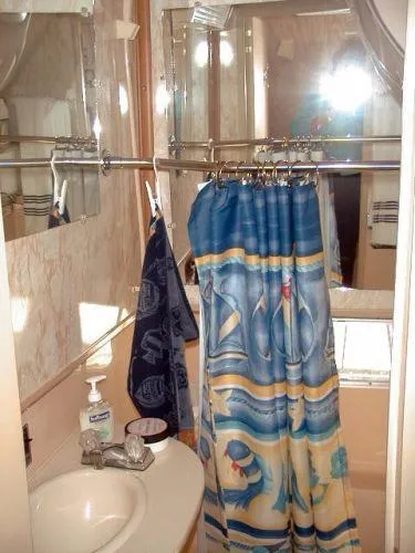 Slide: The Image of Bathroom interior of a 1992 Holiday Mansion houseboat with nautical-themed shower curtain. - 11