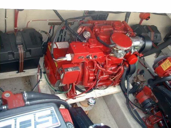 Slide: The Image of Engine compartment of a 1992 Holiday Mansion houseboat, featuring a red engine and wiring. - 12