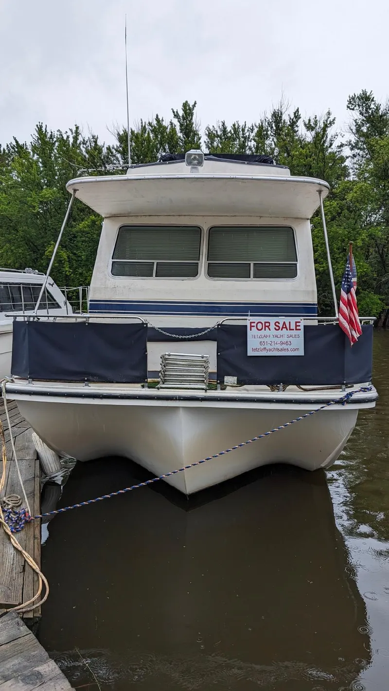 Slide: The Image of 1992 Holiday Mansion houseboat for sale, docked with American flag, front view. - 22