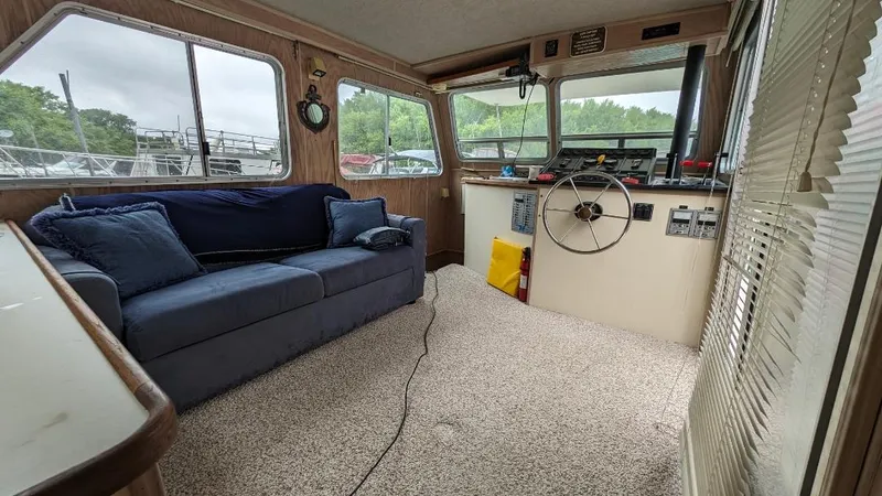 Slide: The Image of Interior of a 1992 Holiday Mansion houseboat with blue sofa and steering area. - 25