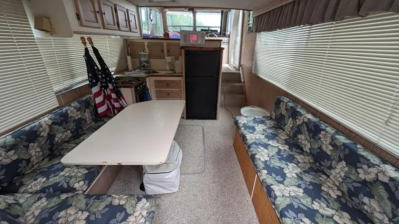 Slide: The Image of Interior of a 1992 Holiday Mansion houseboat with floral seating and dining table. - 27