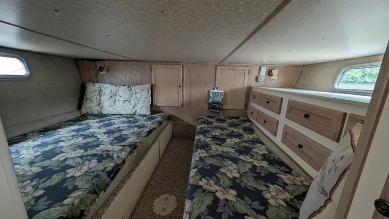 Slide: The Image of 1992 Holiday Mansion houseboat interior with twin beds, floral bedding, and wooden cabinetry. - 31