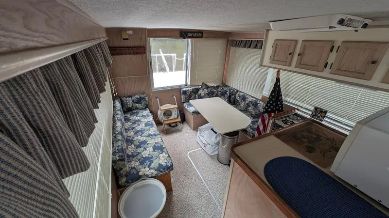 Slide: The Image of Interior of a 1992 Holiday Mansion houseboat with cozy seating and American flag decor. - 33