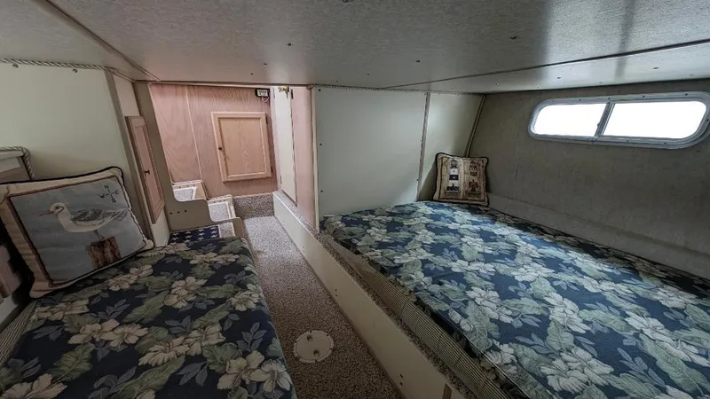 Slide: The Image of 1992 Holiday Mansion houseboat interior with twin beds, floral bedding, and a small window. - 35