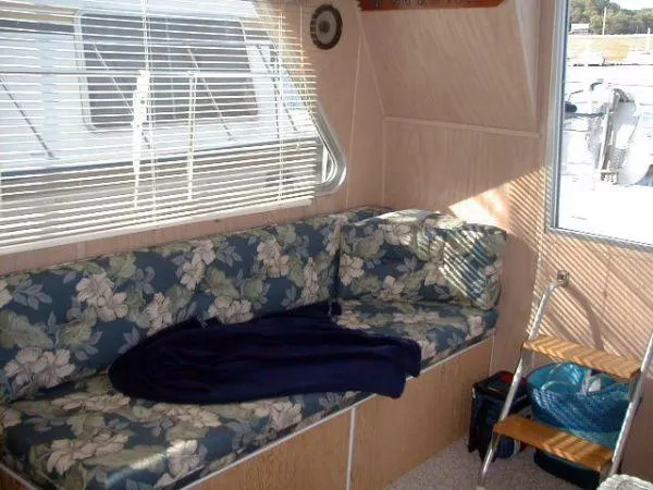 Slide: The Image of Interior of a 1992 Holiday Mansion houseboat with floral-patterned seating and a cozy blanket. - 6