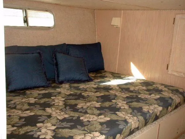 Slide: The Image of Cozy bedroom in a 1992 Holiday Mansion houseboat with floral bedding and blue pillows. - 9