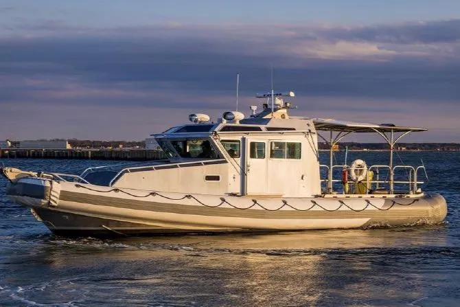 The Image of 2006 SAFE Boats 42 FC navigating on calm waters at sunset. - 1