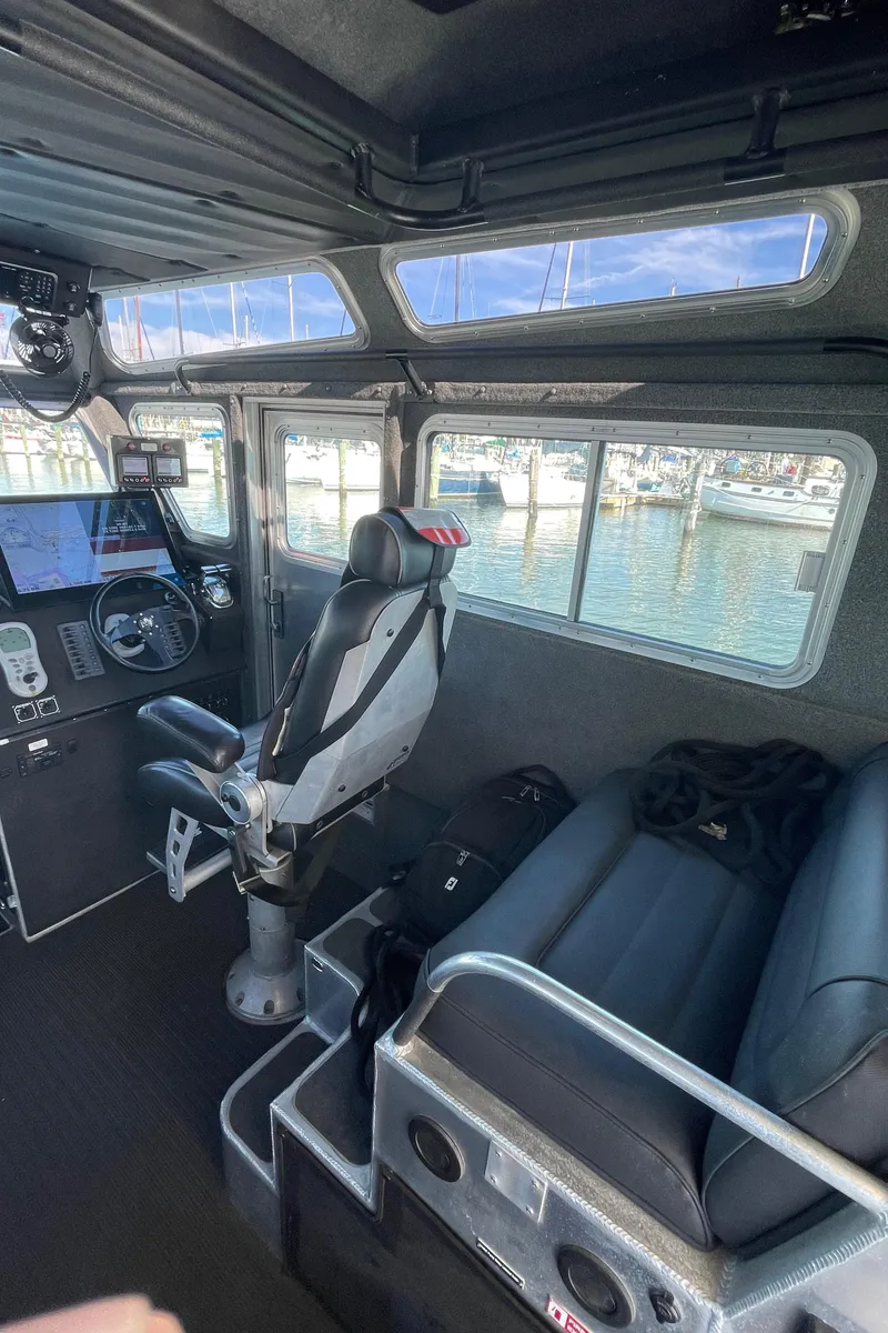 Slide: The Image of Interior of 2006 SAFE Boats 42 FC, featuring helm and seating, with marina view. - 5