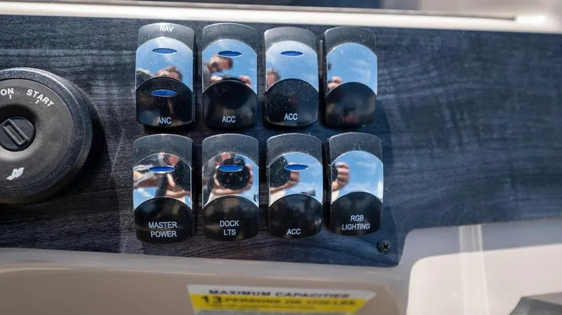 Slide: The Image of Control panel of a 2022 Harris CRUISER 230 SLDH boat with various switches. - 11