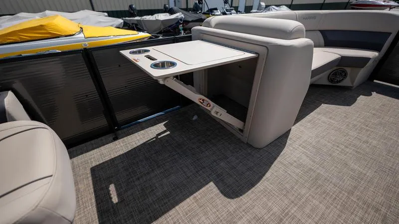 Slide: The Image of 2022 Harris CRUISER 230 SLDH boat interior with fold-out table and cup holders. - 20