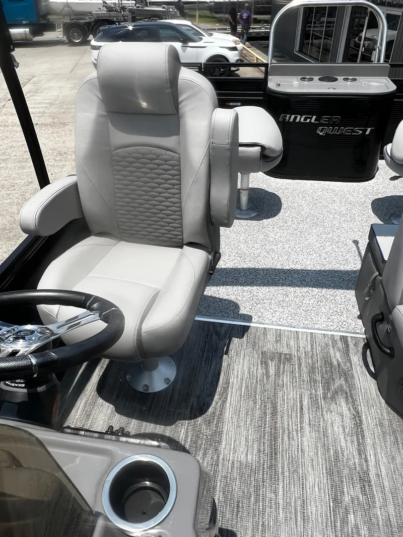 Slide: The Image of 2023 Angler Qwest 8522 Pro Family Fish boat interior with captain's chair and console. - 8