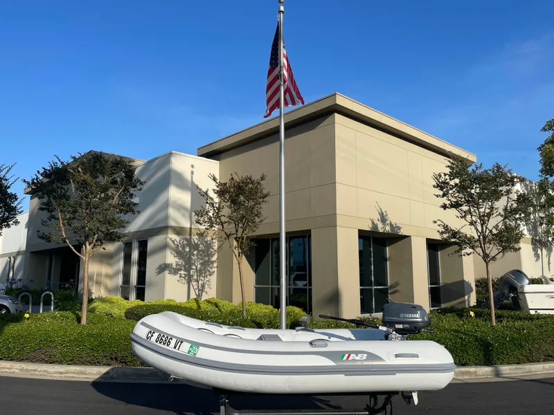 Slide: The Image of 2019 AB Inflatables Navigo 9 VS boat displayed outside a modern building with an American flag. - 5