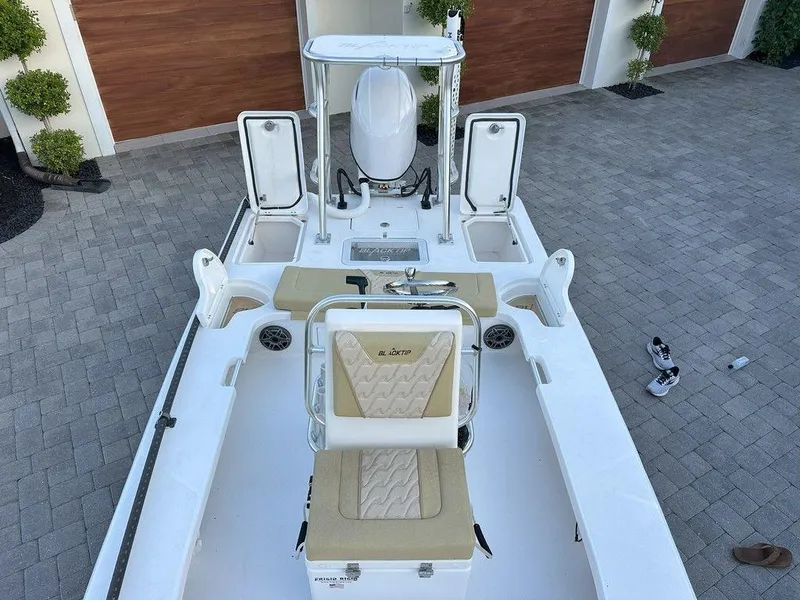 Slide: The Image of 2022 Blacktip Boatworks 18 Flats boat with beige seating and storage compartments. - 13