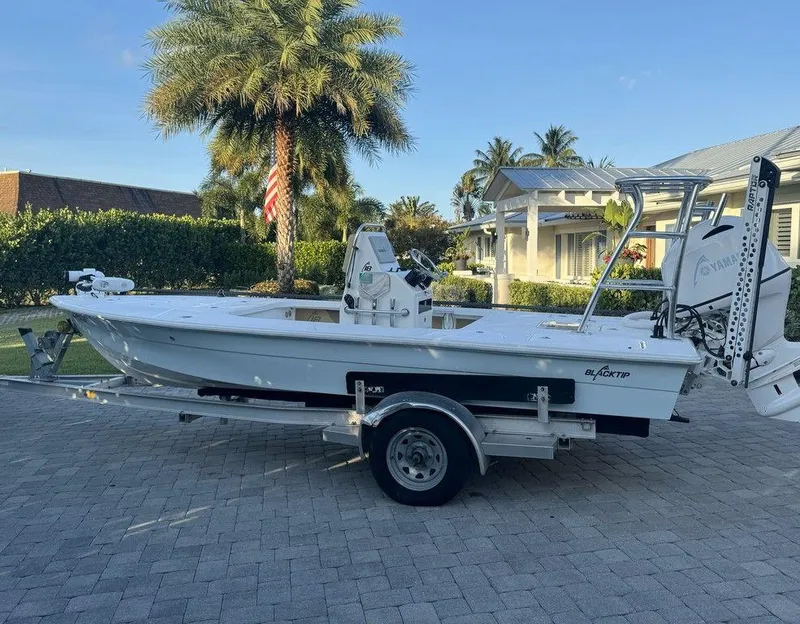 Slide: The Image of 2022 Blacktip Boatworks 18 Flats boat on a trailer in a driveway. - 5