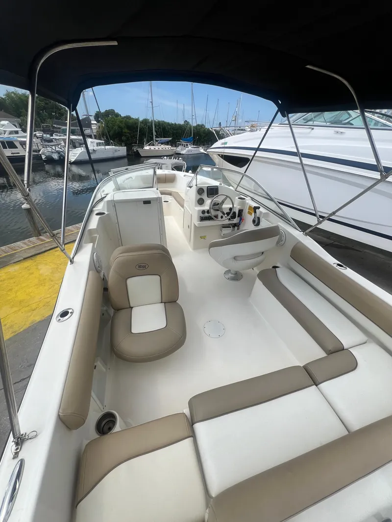 Slide: The Image of 2014 Key West 203 DFS boat interior at marina with seating and console. - 2