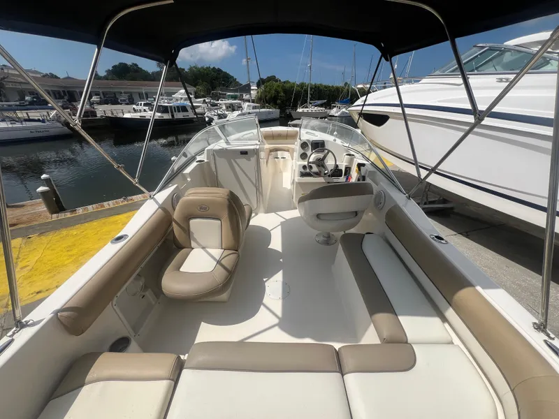 Slide: The Image of 2014 Key West 203 DFS boat interior with seating and steering wheel at marina. - 3