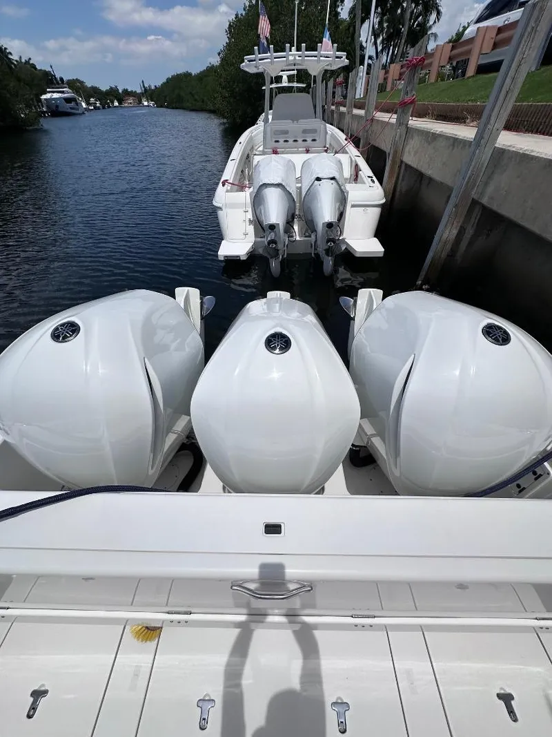 Slide: The Image of 2016 Intrepid 375 Walkaround with triple outboard engines docked by a canal. - 26