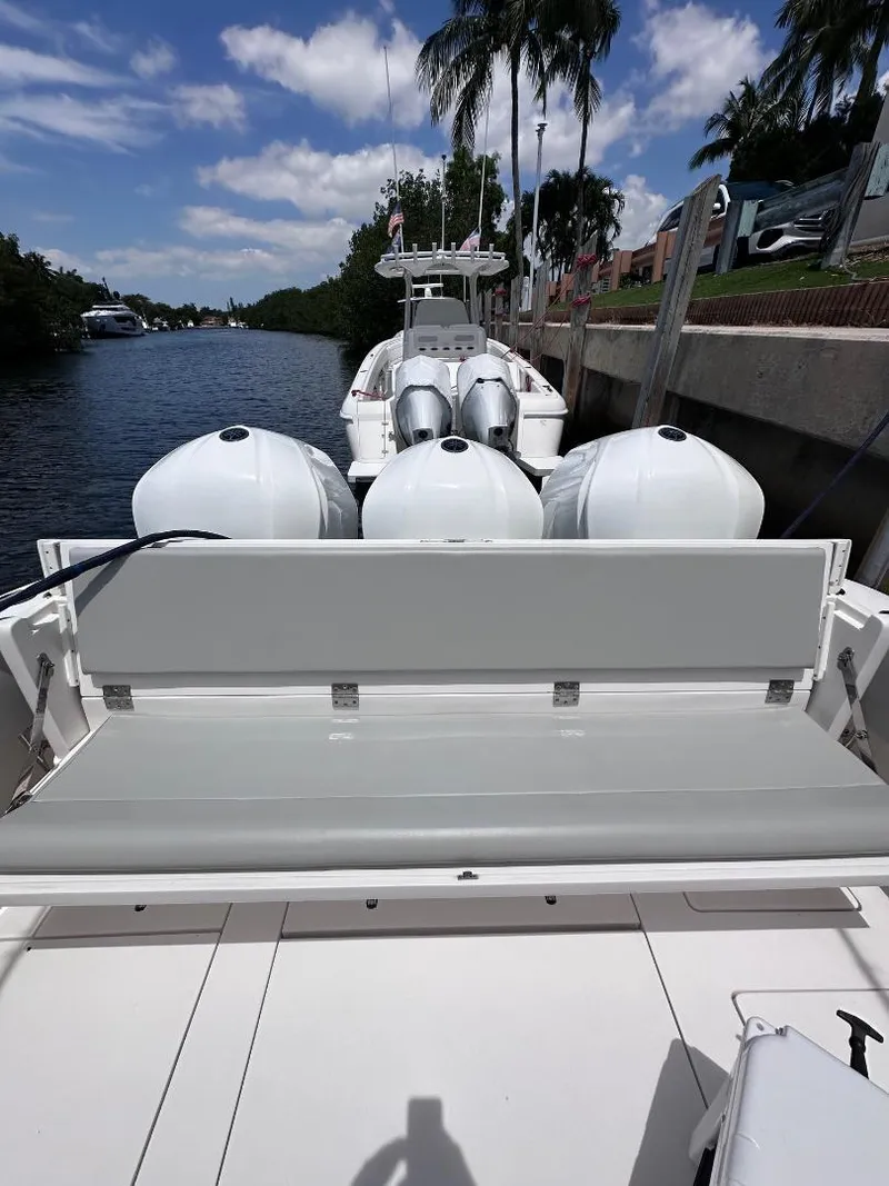 Slide: The Image of 2016 Intrepid 375 Walkaround boat with triple outboard engines docked by a canal. - 29