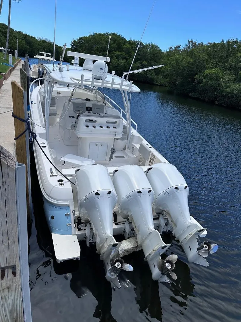 Slide: The Image of 2016 Intrepid 375 Walkaround boat docked by a river. - 39