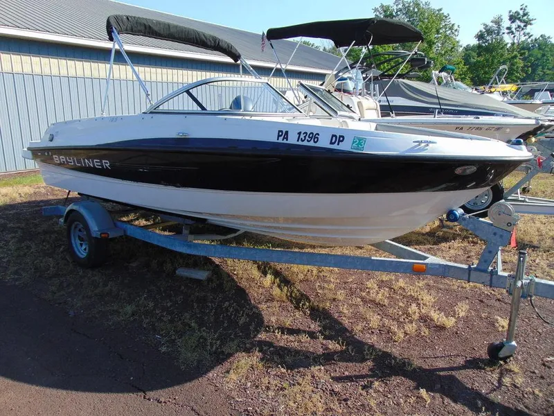 Slide: The Image of 2013 Bayliner 185 Bowrider boat on a trailer in a marina. - 0