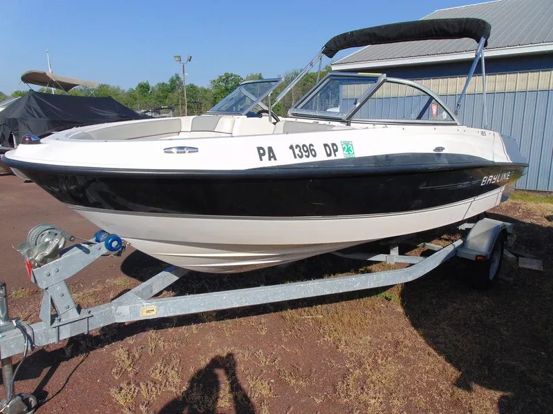 Slide: The Image of 2013 Bayliner 185 Bowrider boat on a trailer, parked outdoors. - 10