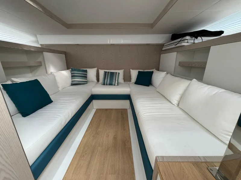 Slide: The Image of Fiart 39 Seawalker 2025 interior with white seating and teal cushions. - 16